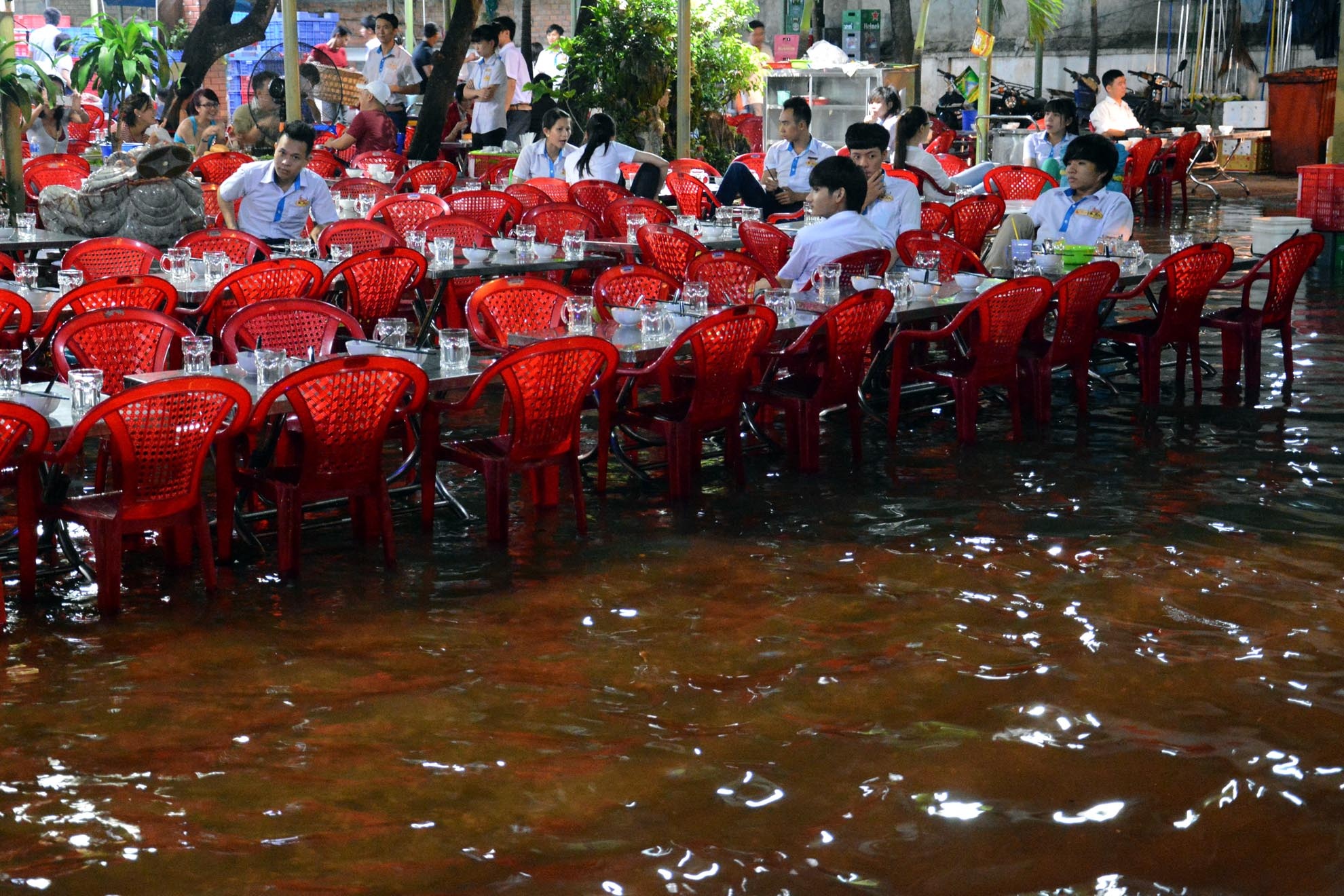 Nhưng không thể áp dụng được ở những nơi mực nước dâng cao do gần sông như quán ăn ở khu vực Thanh Đa này. Nhân viên quán chỉ còn biết ngồi co chân trên ghế chờ nước rút để đóng cửa quán.