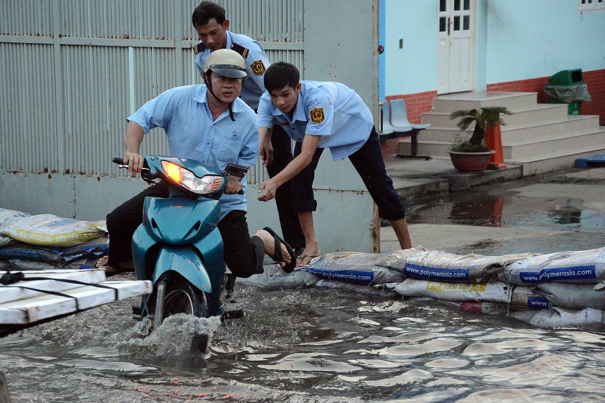 Tại các khu vực thường xuyên bị ảnh hưởng của triều cường như quận 7, quận 8, Bình Thạnh...Người dân đã chủ động đối phó với dâng nước bằng cách dùng bao cát làm bờ bao chặn nước vào nhà.