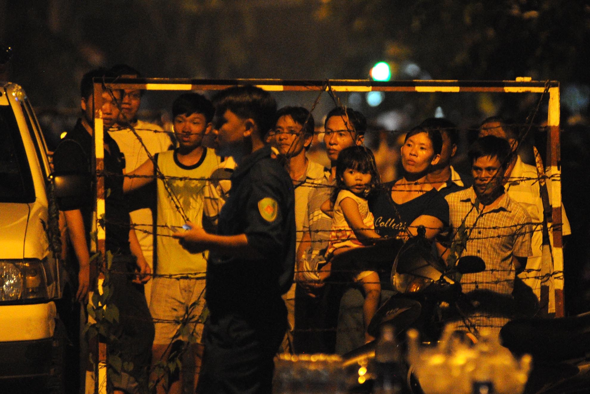 Nhiều gia đình phải di dời ra khỏi khu vực nguy hiểm. Họ đứng ngóng cơ quan chức năng dọn dẹp căn nhà của mình từ ngoài hàng rào.