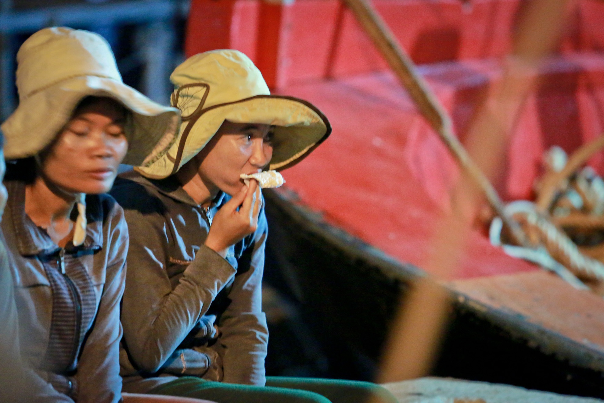 Bữa tối vội vàng của chị Huỳnh Thị Đứng để có sức tiếp tục công việc khiêng cá. Chị cho biết nhiều lúc tàu cập cảng muộn nên chị em phải khiêng cá tới 10g đêm mới xong.