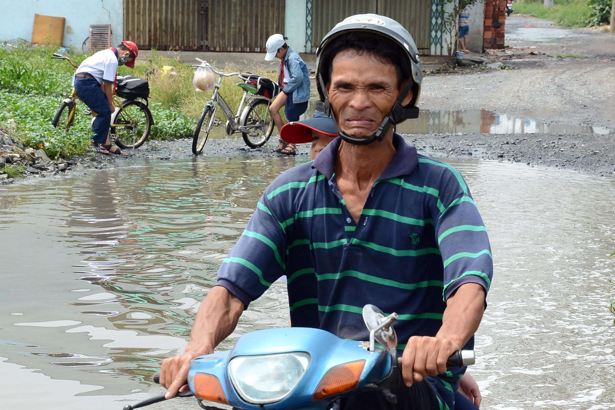 Ngay cả với người lớn thì việc vượt qua đoạn đường ngập đến gần nửa thân xe máy cũng là một nhiệm vụ bất khả thi.