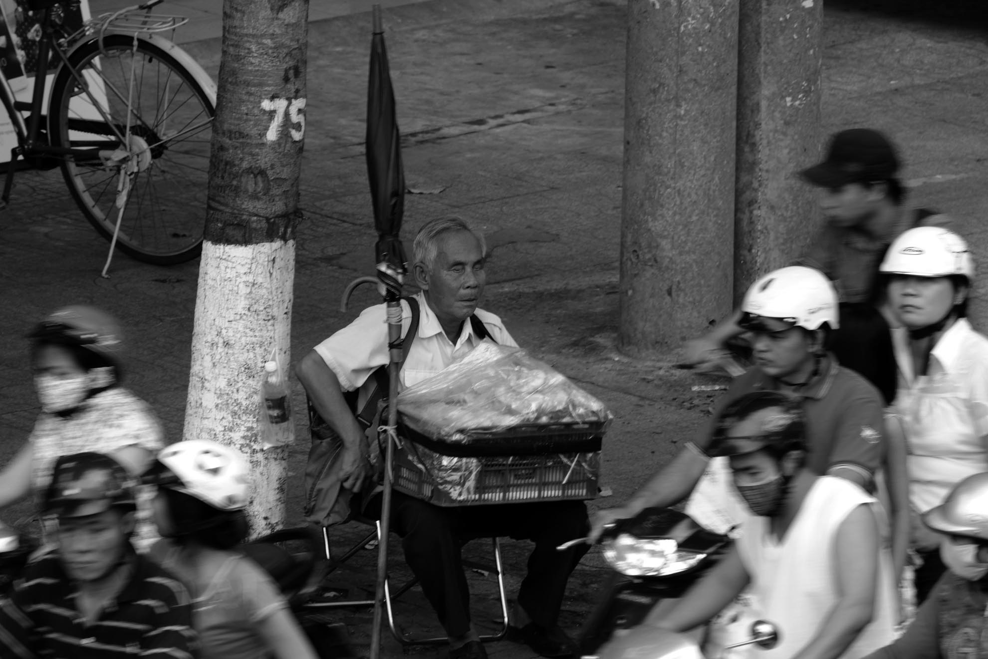 Hàng ngày, người đi trên đường Nguyễn Tri Phương (quận 10) vẫn nhìn thấy một cụ già mù ngồi bán bánh Thửng. Ông là Trương Minh Quang (66 tuổi, ngụ quận 11).