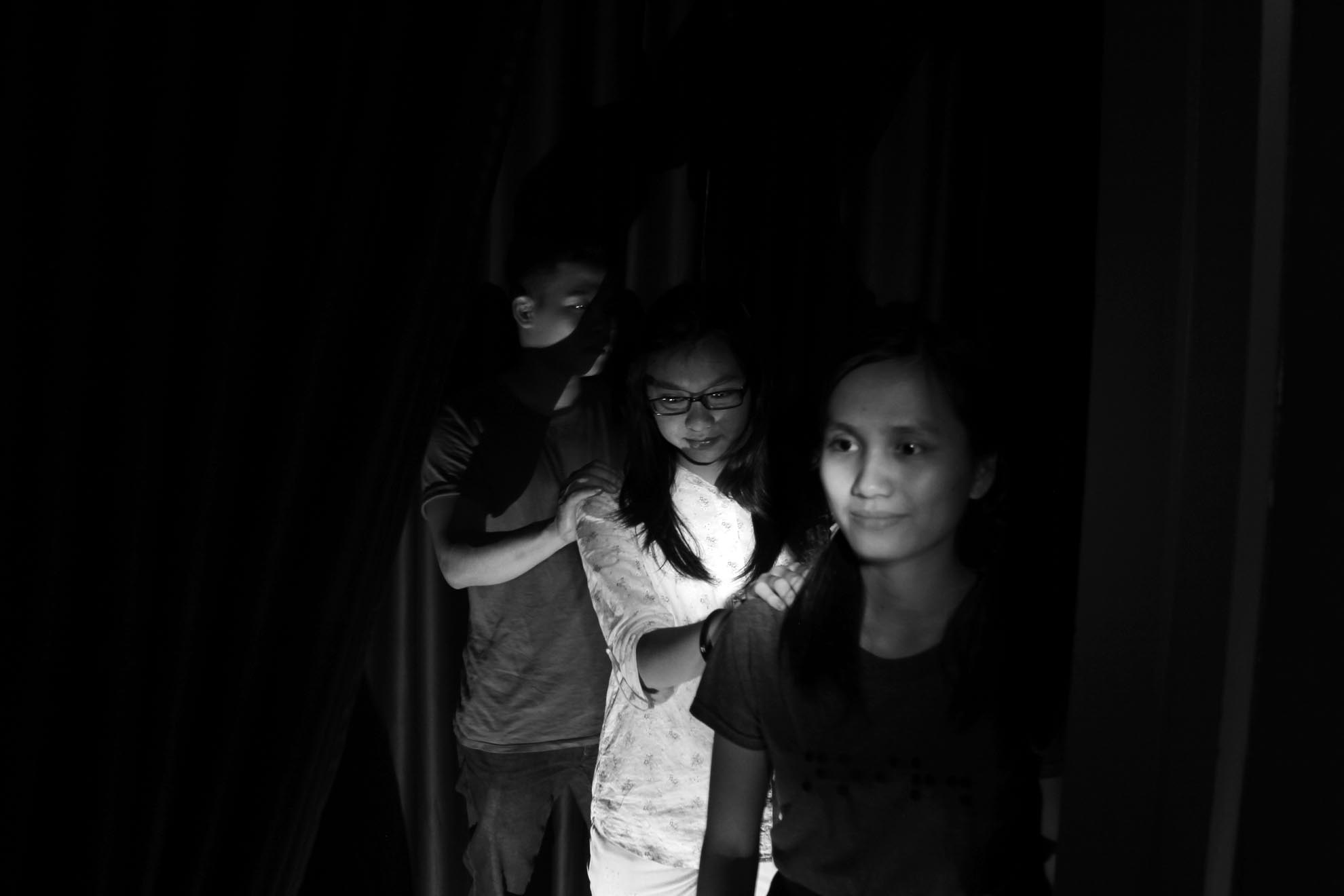 Khách đặt tay lên vai nhân viên khiếm thị để được đưa vào phòng ăn. 