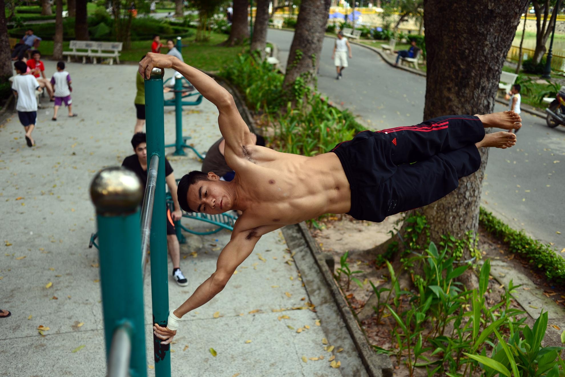 Một bạn trẻ đang hít xà với tư thế nằm ngang, một động tác đòi hỏi sức mạnh cửa cơ bắp.