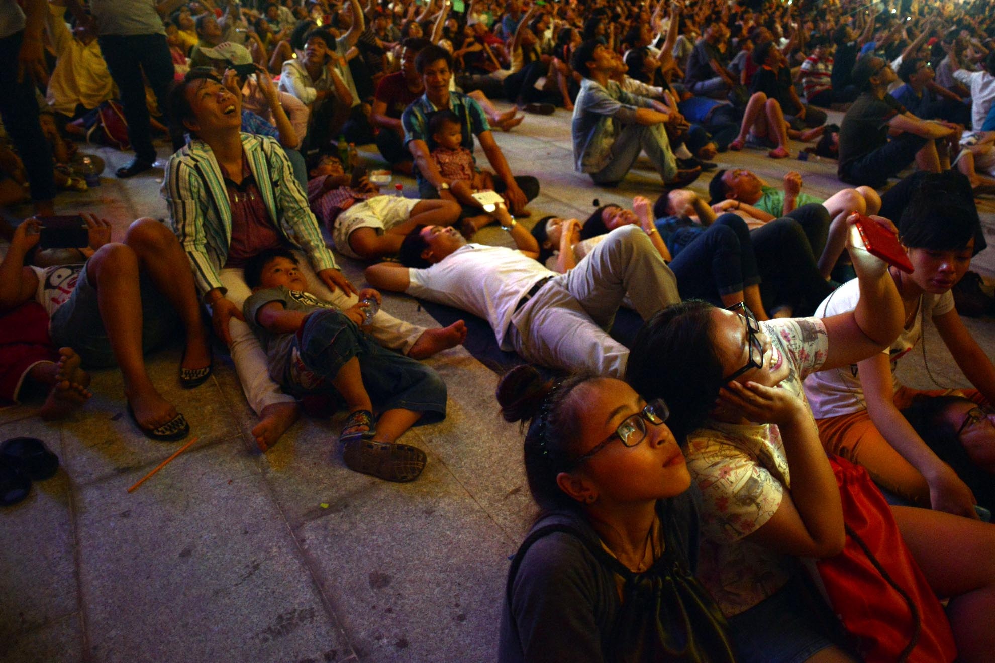 Nhiều người dân nằm hẳn trên nền đá của phố đi bộ vui thú thưởng thức pháo hoa.