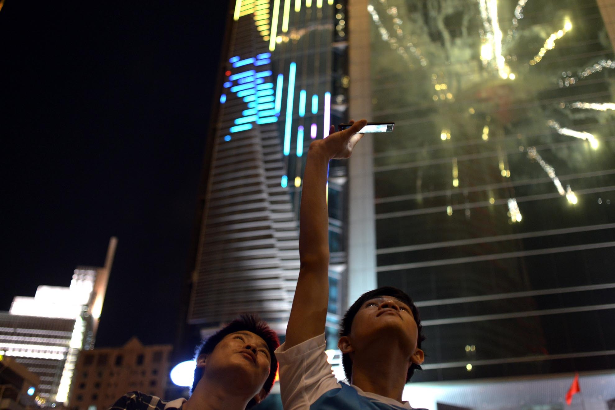 Pháo hoa phản chiếu trên mặt kính của các toà nhà đối diện trên đường Nguyễn Huệ.