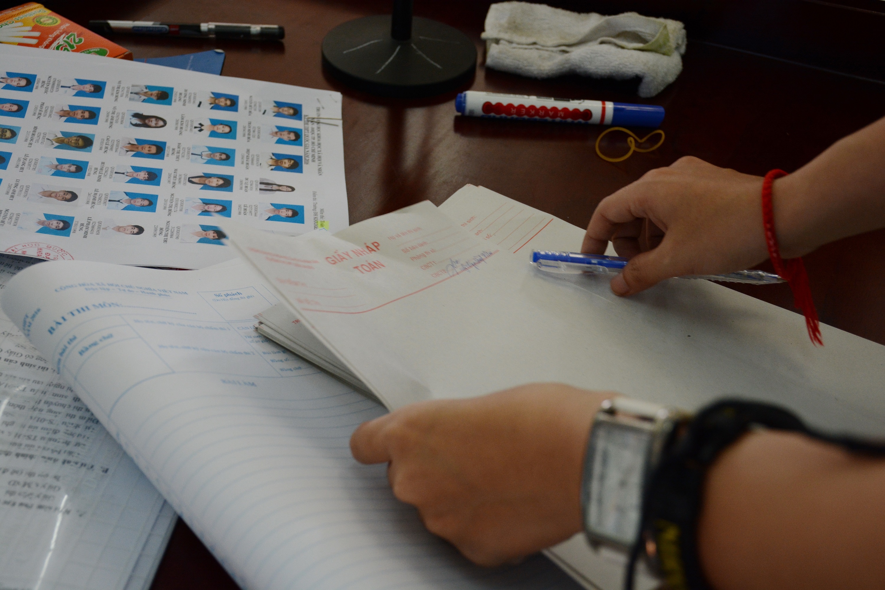 Thi sinh dung dien thoai goi ra ngoai hoi bai hinh anh