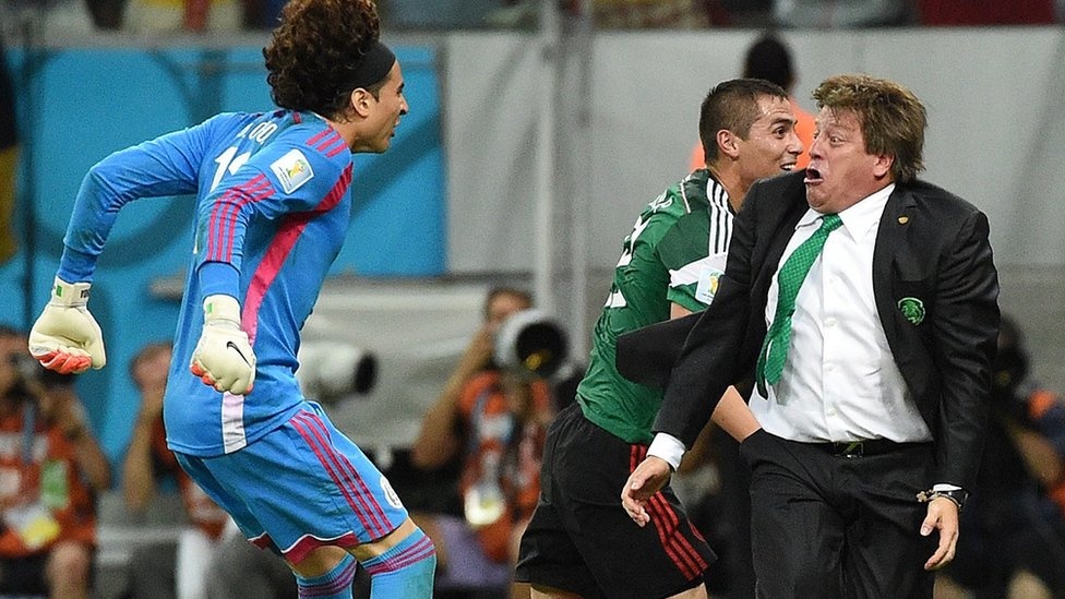 goalkeeper Guillermo Ochoa (L) and Mexico's coach Miguel Herrera (R) celebrate a goal by their team during a Group A football match between Croatia and Mexico at the Pernambuco Arena in Recife.