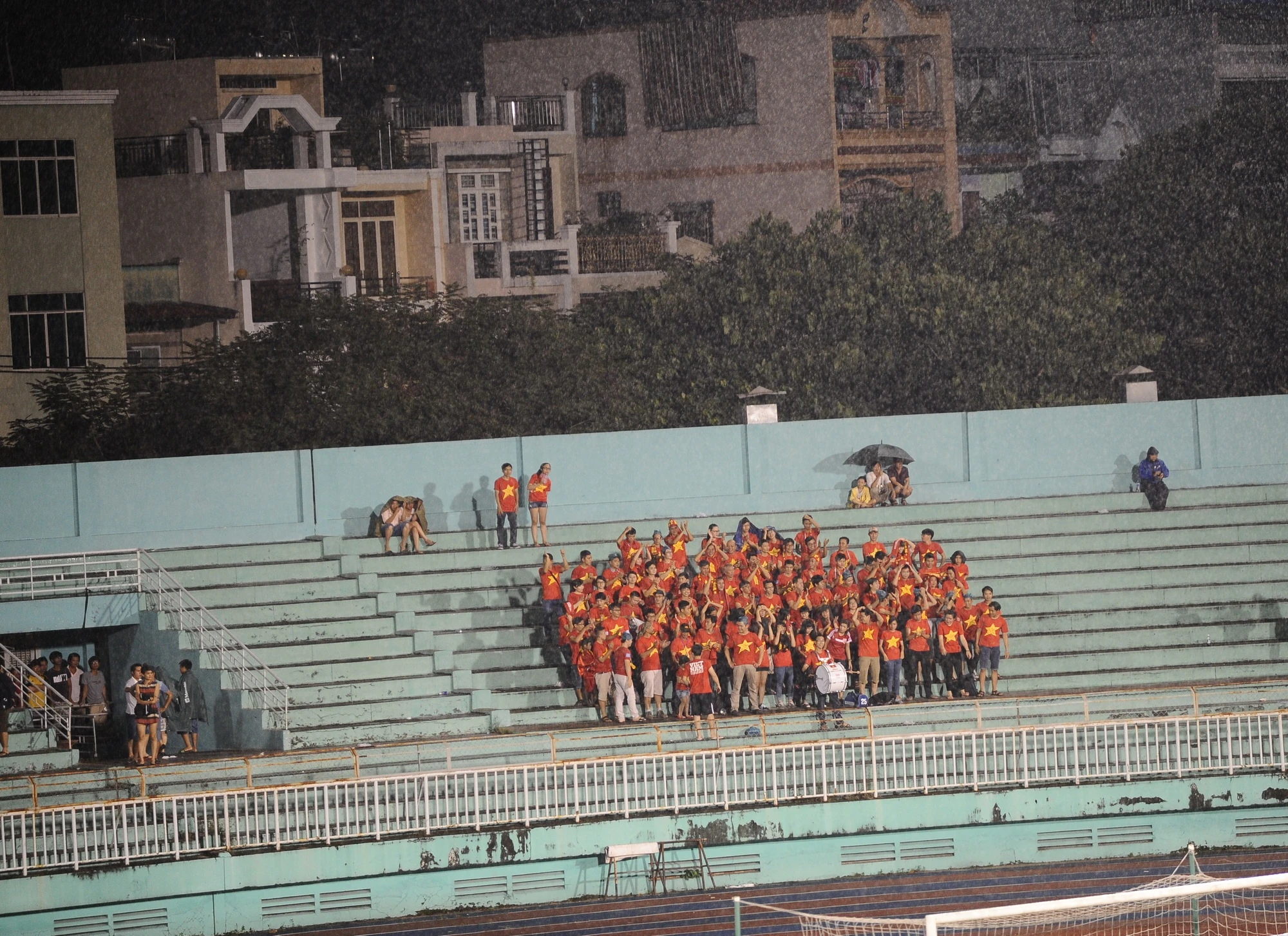 Khán giả đội mưa cổ vũ ĐTVN thi đấu trên sân Thống Nhất.