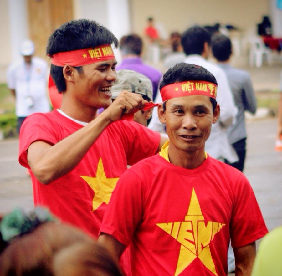Đồng bào Việt Nam tại Lào cùng nhau chuẩn bị trang phục cổ vũ trước khi vào sân tiếp lửa U19 Việt Nam. 