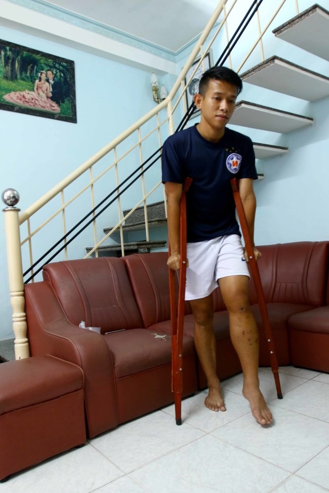 Anh Khoa di chuyển hết sức khó khăn với đôi nạng gỗ do chấn thương gối của anh rất nghiêm trọng và phức tạp. Ảnh: THẮNG LÊ