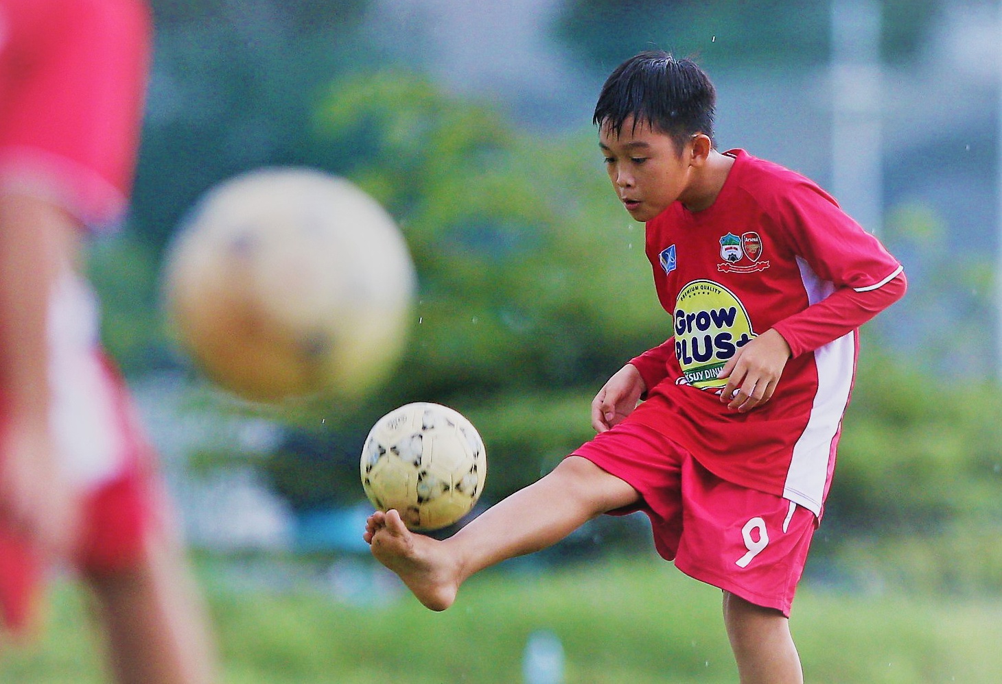 Cau thu nhi da bong chan dat tai Hoc vien NutiFood JMG TP.HCM hinh anh