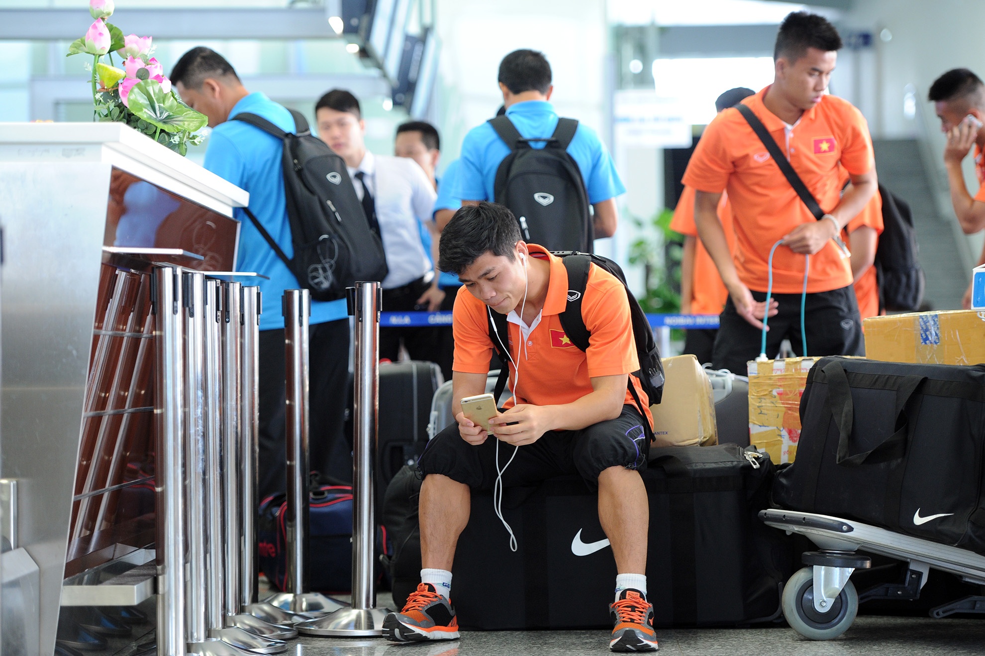 Phượng lặng lẽ ngồi một góc nghe nhạc trong lúc chờ đợi ban huấn luyện làm thủ tục hải quan. Thỉnh thoảng lại có fan nữ ra xin chụp ảnh cùng cầu thủ số 10 đội U23 Việt Nam.