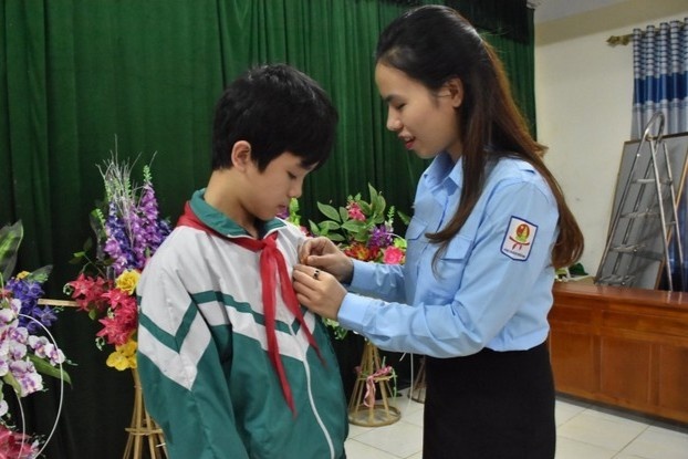 Trao huy hieu cho nam sinh cuu hai em nho khoi duoi nuoc hinh anh