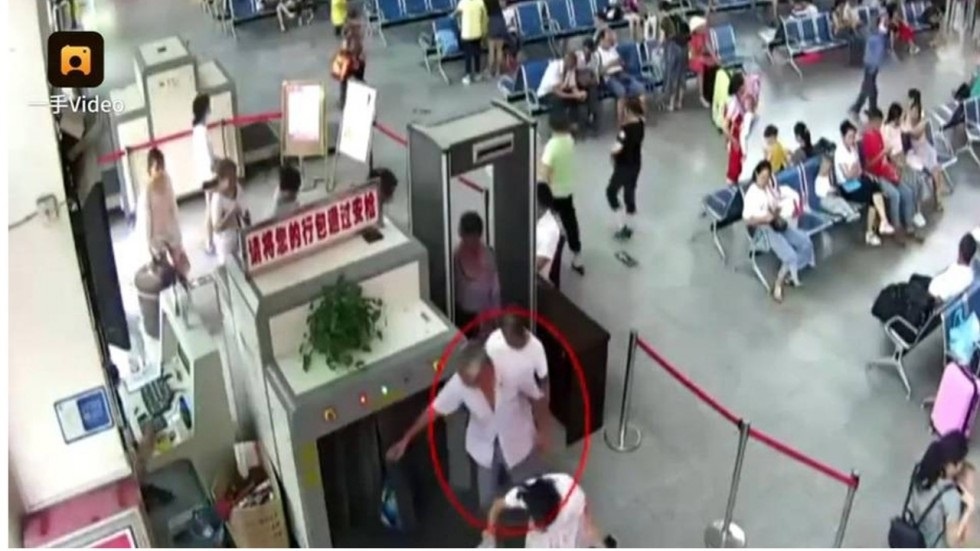 Nguoi dan ong TQ bi giu voi 2 canh tay bi chat de trong tui hinh anh