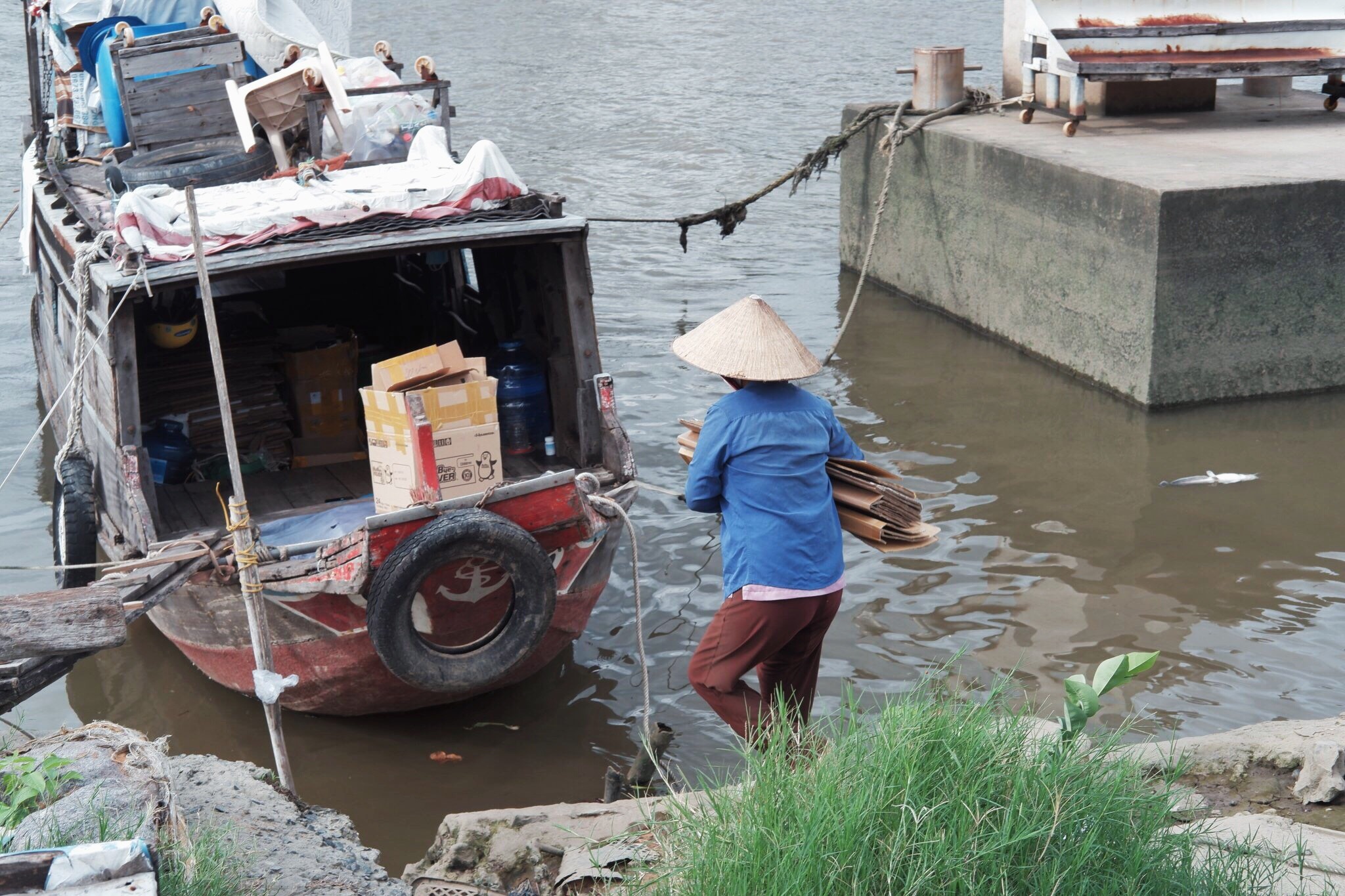 Nguoi phu nu lui thui tren chiec thuyen o TP.HCM hinh anh