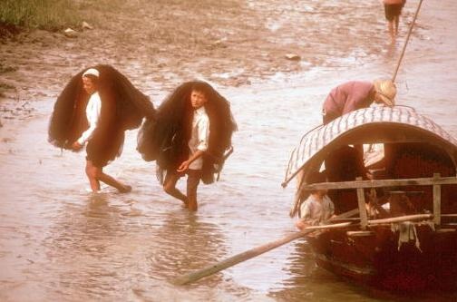 Hai ngư dân thu lưới sau một ngày đánh cá ở con sông tại Vinh năm 1980.