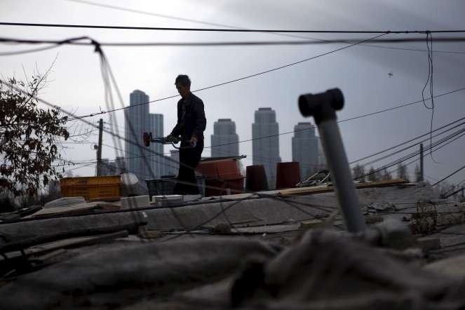 Người phụ nữ phơi quần áo tại căn nhà tạm của bà ở khu Guryong, đằng sau là các tòa nhà cao tầng sang trọng ở quận Gangnam.