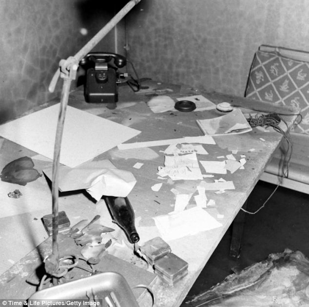 Giấy tờ và nhiều vật dụng ngổn ngang trên cái bàn gần ghế sofa bị cháy. 2 tuần sau khi Hitler tự sát, nhiếp ảnh gia William Vandivert là nhà báo đầu tiên được vào căn hầm này.