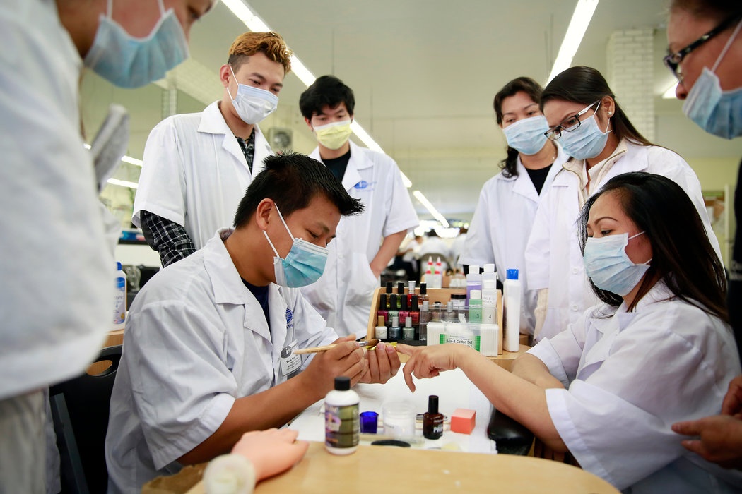 Anh Toan Ngoc Do, một học viên làm nail, đang sơn móng cho học viên khóa trên tại cơ sở đào tạo ở thành phố San Francisco, bang Los Angeles. Ảnh: NYT