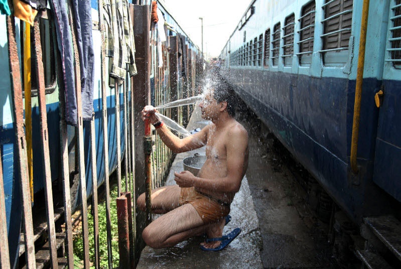 Một người đàn ông tắm ở một trạm tàu hỏa ở Jammu, Ấn Độ vào ngày 25/5. Nhiều vùng ở Ấn Độ, bao gồm thủ đô New Delhi, đã trải qua những ngày nắng nóng gay gắt. Nhiệt độ tại một số thành phố ở hai bang Telangana và Andhra Pradesh có khi đến 48 - 49 độ C, theo AFP.