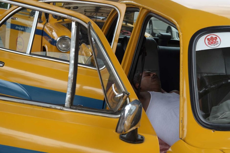 Một tài xế ngủ trong xe ở thành phố Kolkata, bang Tây Bengal. Liên đoàn taxi tại thành phố khuyến cáo tài xế hạn chế ra đường trong thời gian này. Còn đài SBS (Australia) ví Ấn Độ như một 