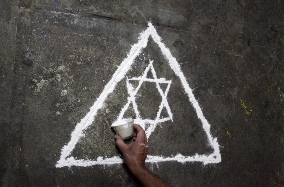 Thầy pháp Joaquin vẽ một biểu tượng lên bức tường trong nhà trước khi bắt đầu nghi lễ.