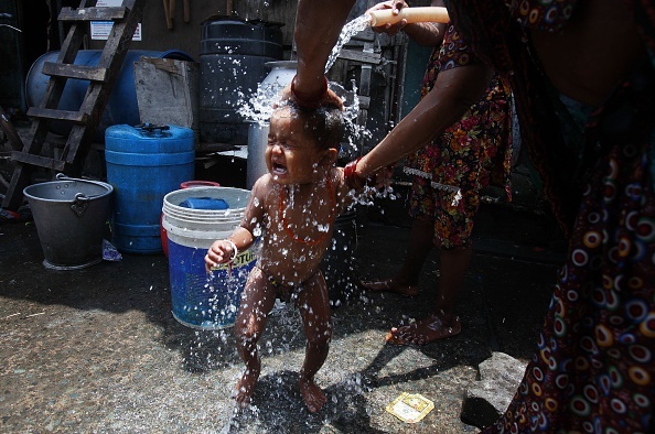 Một bà mẹ tắm cho con tại Mumbai ngày 29/5. Theo trang Hindustan Times, số người thiệt mạng vì nắng nóng trên cả nước đã vượt mốc 2.000 người vào ngày 30/5. 