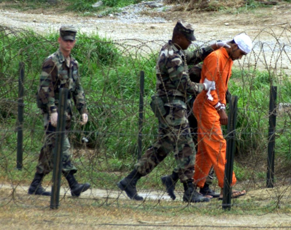 Lính canh tại nhà tù ở Guantanamo dẫn một binh sĩ đến phòng thẩm vấn. Majid Khan, 35 tuổi, là người Pakistan. Anh là 