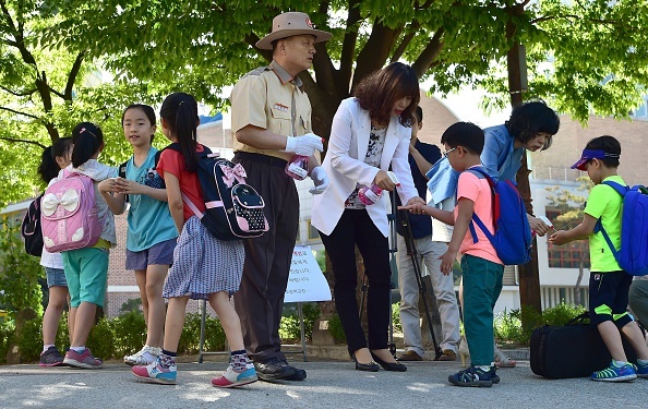 Các giáo viên và nhân viên y tế xịt nước rửa tay chống vi khuẩn cho các học sinh. Hàn Quốc chính thức xác nhận trường hợp tử vong vì virus MERS đầu tiên vào đầu tuần qua, người bệnh là một thiếu niên 16 tuổi.  