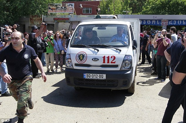 Xe của Bộ Khẩn cấp chở xác con hổ rời khỏi hiện trường xung quanh nơi mà nó vồ chết người.