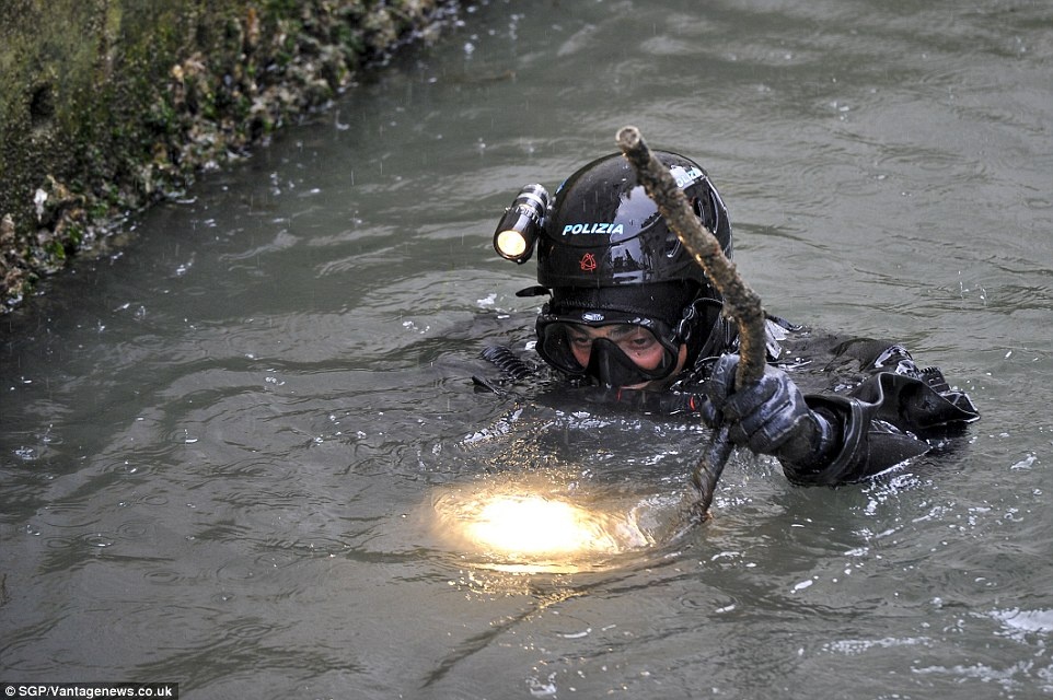 Một nhân viên an ninh ở Venice kiểm tra bên dưới các kênh đào để bảo đảm an ninh trước khi đón tiếp Đệ nhất Phu nhân Mỹ. Thành phố thơ mộng của Italy là một trong những chặng dừng chân của bà Obama cùng thân mẫu và hai con gái trong chuyến công du châu Âu.