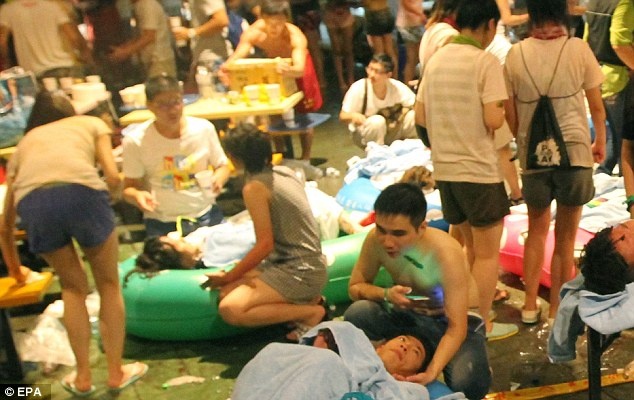 Bạn bè an ủi những người bi thương sau vụ cháy. Ảnh: EPA