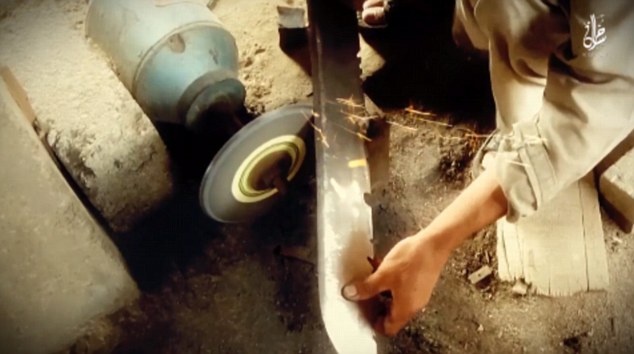 Phiến quân mài kiếm trước khi xử tử tù binh. Ảnh: