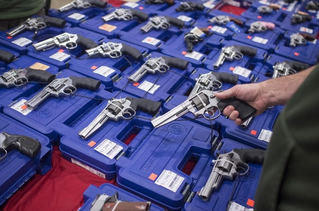 Một vị khách đang chọn khẩu súng ngắn tại hội chợ. Quyền sở hữu súng được xem là một trong những quyền cơ bản của người dân Mỹ, nó được quy định cụ thể trong Tu chính án thứ hai trong Hiến pháp Mỹ.