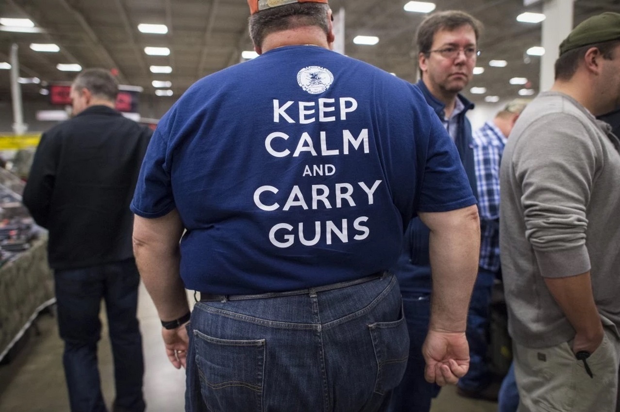 Ông Terry Eyler đi tham quan hội chợ súng ngày 3/10. Ông mặc dòng áo thun in chữ 