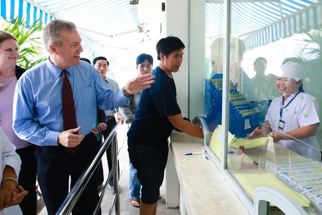 Một bệnh nhân nhiễm HIV nhận hồ sơ điều trị trong lúc Đại sứ Mỹ Ted Osius thăm Trung tâm Tham vấn Hỗ trợ Cộng đồng HIV/AIDS quận 4. Ảnh: Hải An