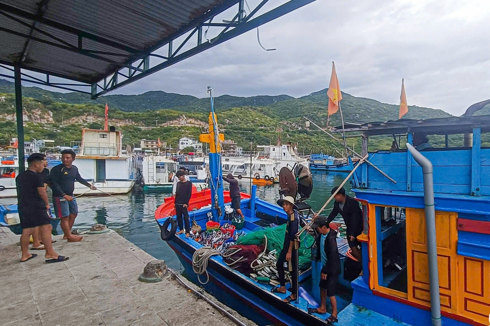 Canh khach chen chuc voi tau ca tren vinh Vinh Hy hinh anh