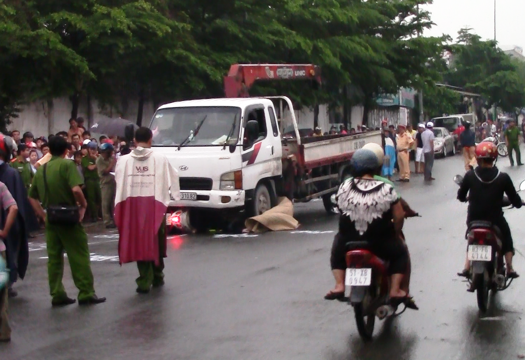 Xe tai cuon 2 nu cong nhan vao gam trong con mua hinh anh