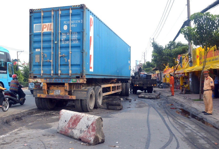 Xe dau keo tong dai phan cach, cuon nguoi dan ong vao gam hinh anh