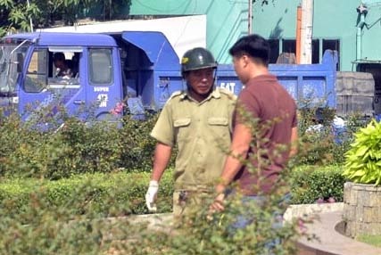 Nguoi dan ong uong thuoc tru sau giua vong xoay o Sai Gon hinh anh