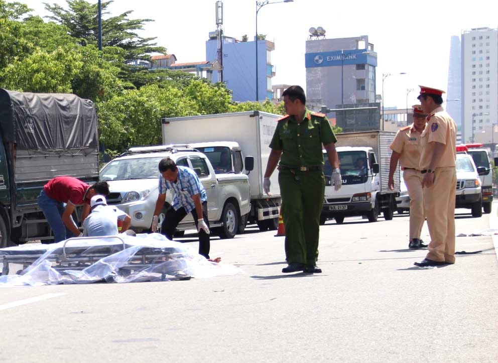 Nguoi phu nu bi xe tai can tu vong sau khi tong dai phan cach hinh anh