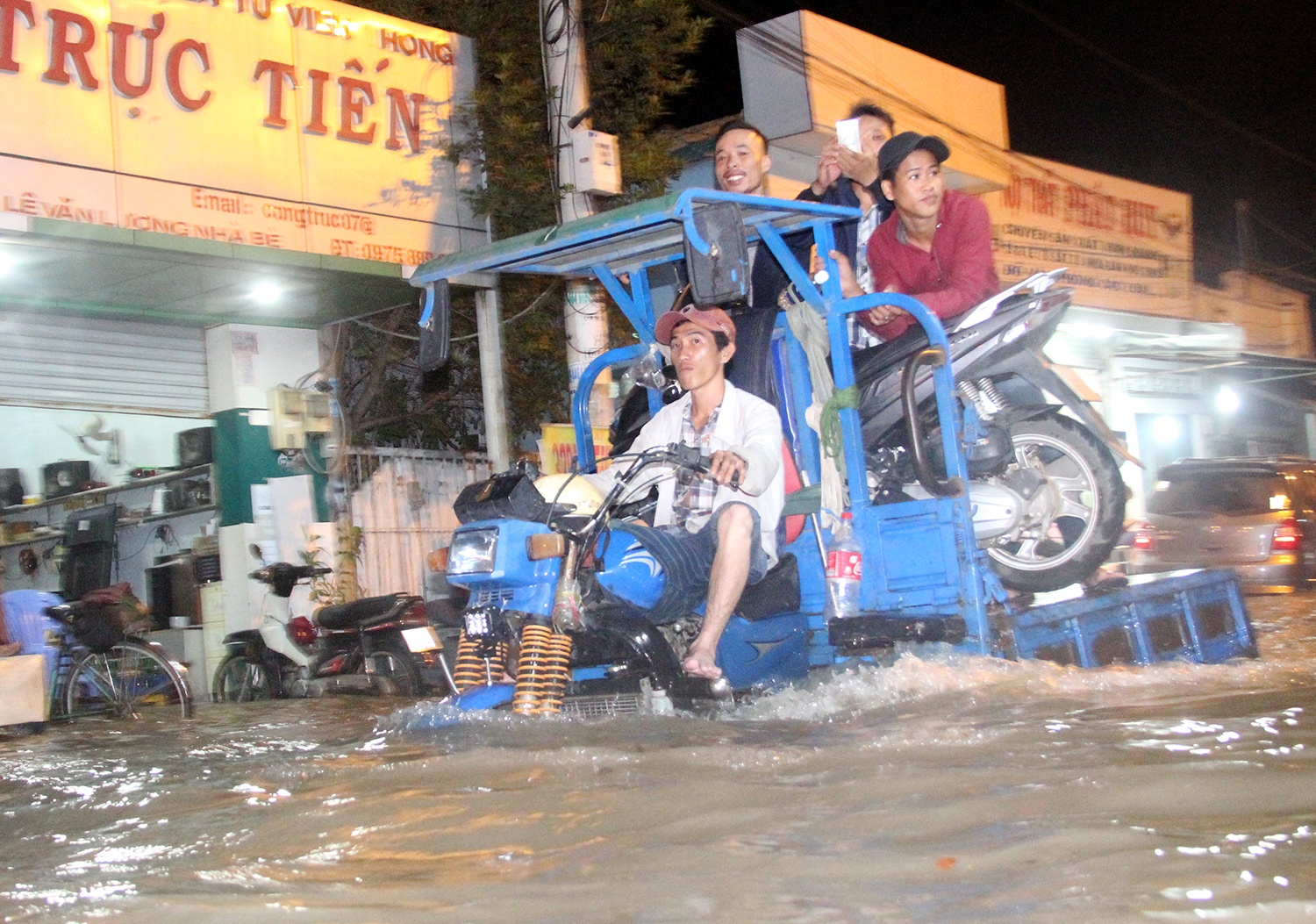 Kiem tien nho dich vu cho xe may qua nuoc ngap o Sai Gon hinh anh