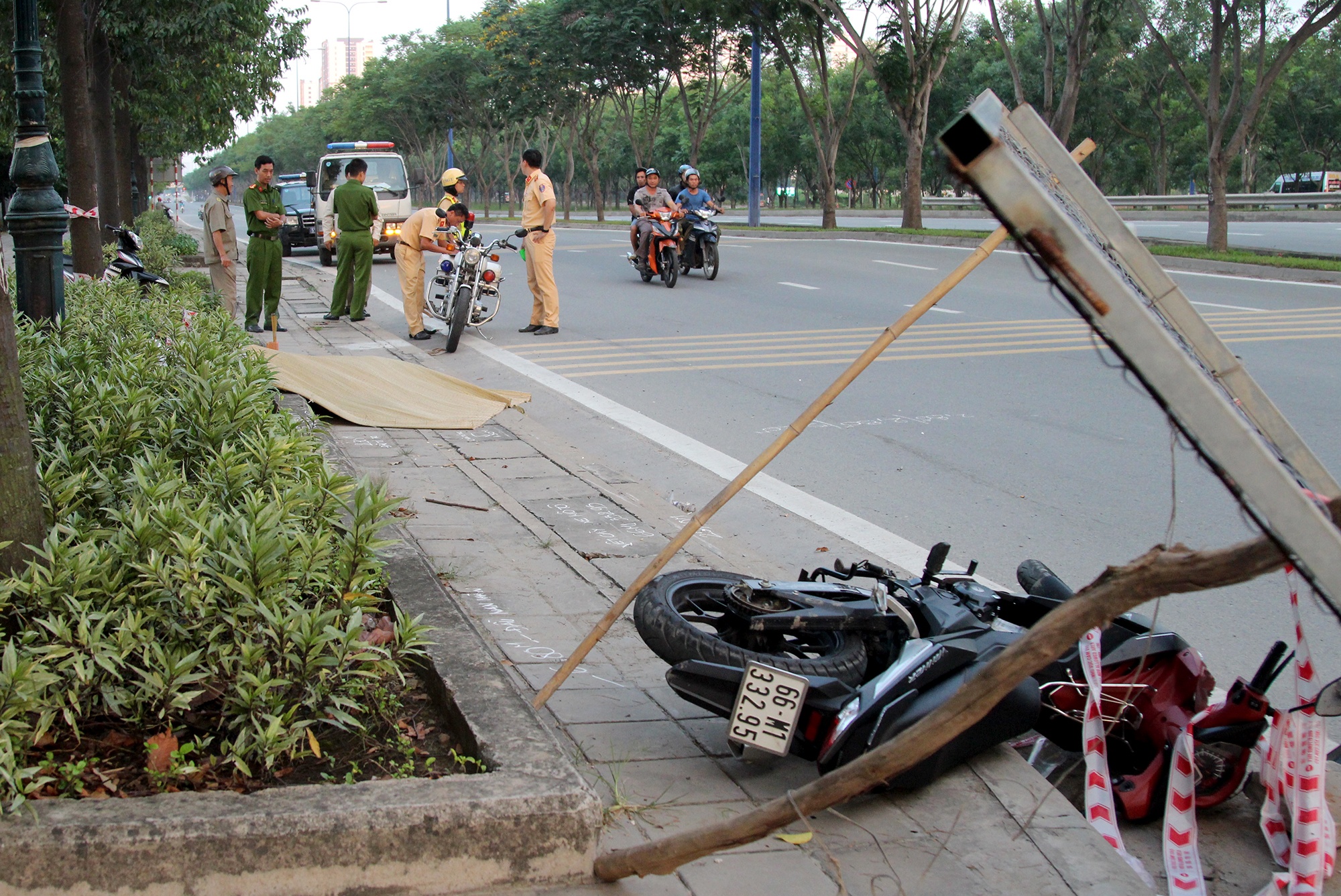 Nam thanh nien guc chet canh xe may tren via he Sai Gon hinh anh