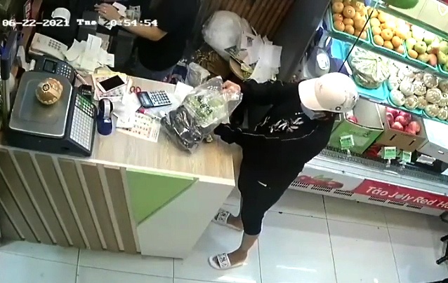 Nguoi phu nu trom dien thoai trong cua hang trai cay hinh anh