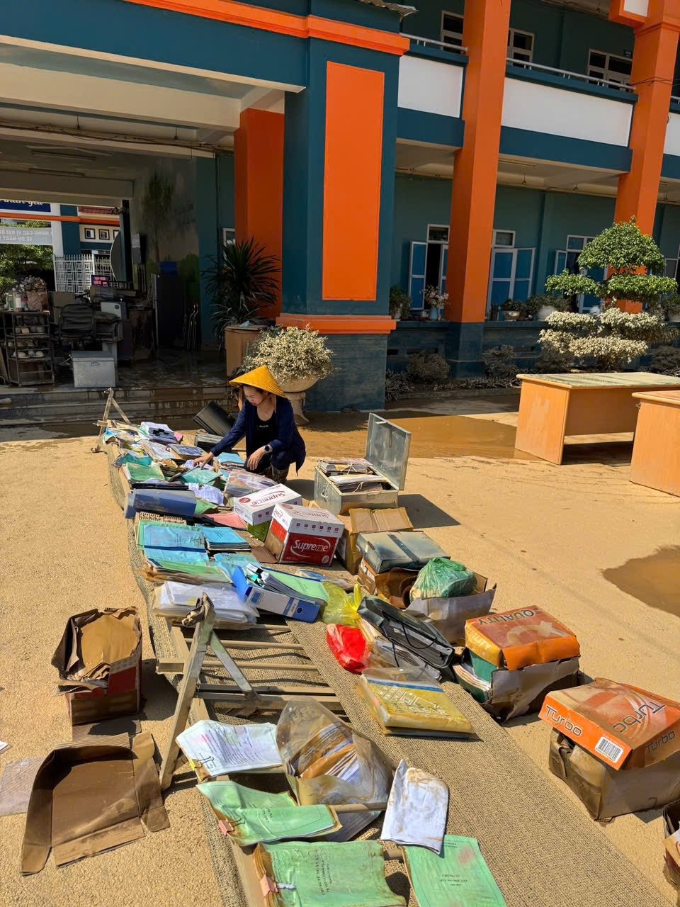 Trong ảnh, cô Bùi Thị Thanh Hoàn, Hiệu trưởng trường Tiểu học và THCS 915 Gia Sàng (Thái Nguyên), đang phơi các loại hồ sơ bị ngập. Ảnh: FBNT.