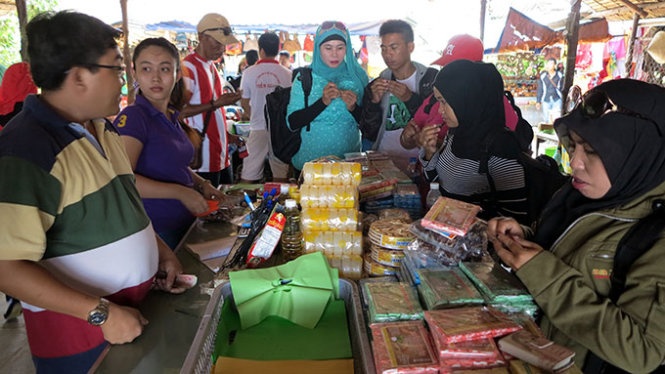 Một nhóm du khách đạo Hồi đến từ Indonesia đang chọn mua hàng tại một điểm bán bánh kẹo ở Mỹ Tho (Tiền Giang) - Ảnh: Lê Nam