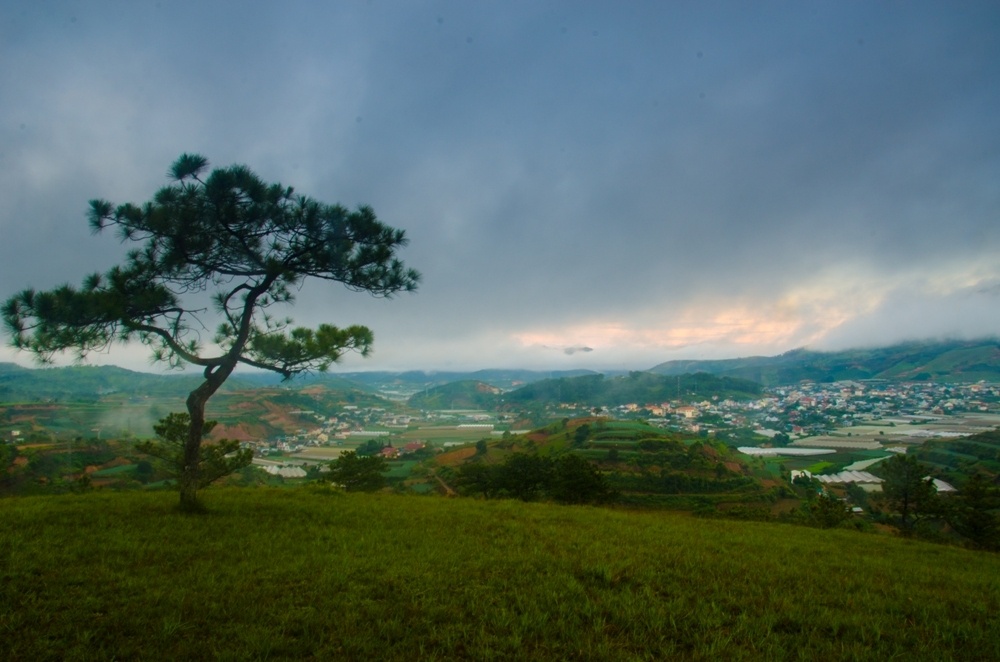 Bình minh sương mù nhìn xuống thị trấn Lạc Dương – Đà Lạt. Sương mù dày đặc làm le lói ánh sáng mặt trời xuyên qua nhưng không thể lọt xuống được thành phố. 
