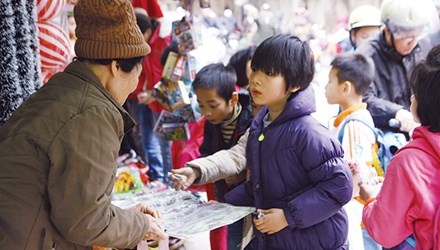 Học sinh tiểu học ở Hà Nội đang mua miếng dán độc hại có xuất xứ Trung Quốc trước cổng trường. 