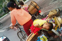Ảnh người mẹ nghèo chở con nằm ngủ trên xe gây tranh cãi 